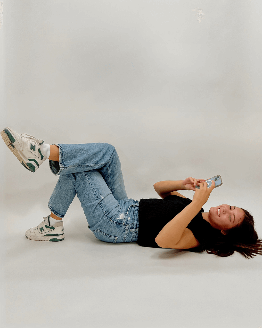 a woman lying on the floor holding a phone